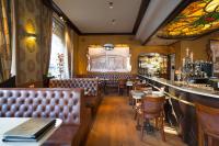 um restaurante com assentos de couro e um bar em Hotel Grupello em Geraardsbergen