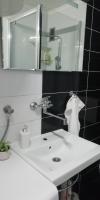 a bathroom with a white sink and a mirror at Apartment M&amp;A in Osijek