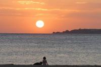 a woman sitting on the beach watching the sunset at Fei Li Jin Hotel in Kenting