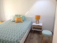 a small bedroom with a bed and a stool at Duplex en plein centre in Propriano