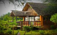 una pequeña casa con techo de paja en Teen Ranch Kenya, en Amboseli