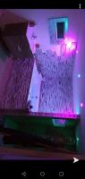 a room with two rows of chairs and purple lights at Le Menhir Jacuzzi Lit 200x200 in Le Cendre