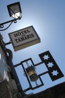 a sign for a hotel in the timbers and a street light at Hôtel Aux Tamaris - Vue Mer in Roscoff