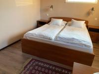 A bed or beds in a room at Aurora Panzió