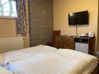 A bed or beds in a room at Aurora Panzió