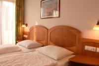 A bed or beds in a room at Aurora Panzió