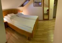 A bed or beds in a room at Aurora Panzió