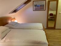 A bed or beds in a room at Aurora Panzió