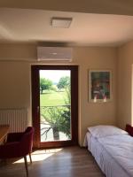 A bed or beds in a room at Aurora Panzió