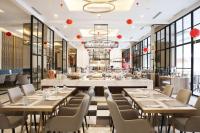 Un restaurante con mesas, sillas y ventanas. en Bigland Bogor Hotel Powered by Archipelago, en Bogor