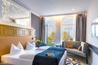アールベックにあるSEETELHOTEL Ostseehotel das Entdeckerhotel an der Ostsee und der perfekte Startpunkt für Ihre Inselabenteuerのベッドとソファのあるホテルの部屋