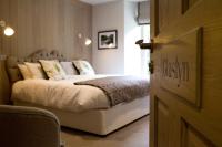 Un dormitorio con una cama con sábanas y almohadas blancas. en Saracens Head, en Beddgelert