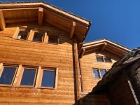 a wooden house with windows on the side of it at Hotelski in Verbier