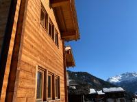 a wooden building with windows and mountains in the background at Hotelski in Verbier