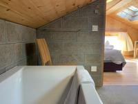 a bathroom with a tub and a bedroom with a bed at Hotelski in Verbier