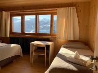 a bedroom with two beds and a table and a window at Hotelski in Verbier