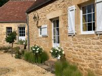 a stone house with flowers in front of it at Gîte chez le Gaulois in Carsac-Aillac