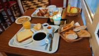 a table with a tray of breakfast foods and coffee at Fasthotel Angers Beaucouzé in Beaucouzé