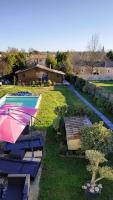 un patio trasero con piscina y sombrilla rosa en Chalet des 2 moutons, en Le Taillan-Médoc