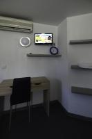 a room with a desk and a tv on a wall at Dortoirs Rocade 2 in Pamiers
