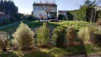 una casa con un patio con plantas delante en Chalet des 2 moutons, en Le Taillan-Médoc