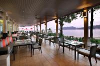 a restaurant with tables and chairs and a view of the water at Amari Phuket in Patong Beach