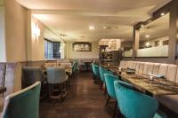 een eetkamer met blauwe stoelen en tafels bij White Lion Hotel in Crewe