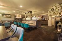 een restaurant met blauwe stoelen en een bar bij White Lion Hotel in Crewe