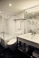a bathroom with a toilet and a sink and a tub at Reddot Hotel in Taichung