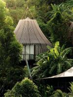 a building with a thatched roof in the forest at Keemala in Kamala Beach