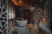 a bathroom with a black and white patterned wall at Keemala in Kamala Beach