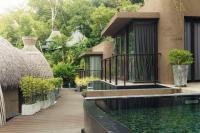 a resort with a pond in front of a building at Keemala in Kamala Beach
