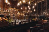 a bar in a restaurant with wooden walls and lights at Keemala in Kamala Beach