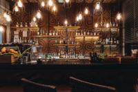 a bar with a wooden wall with liquor bottles at Keemala in Kamala Beach
