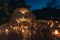 a dinner table in a cage with candles on a deck at Keemala in Kamala Beach