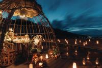 a dinner table on a deck with candles at Keemala in Kamala Beach