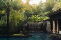 a waterfall in a garden with a pool of water at Keemala in Kamala Beach