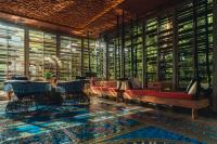 a lobby with benches and tables and windows at Keemala in Kamala Beach