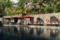 a swimming pool with chairs and umbrellas next to a resort at Keemala in Kamala Beach