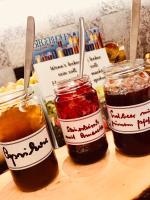 tres frascos de mermelada en una tabla de cortar con cucharas en Haus Fliederbusch, en Borken