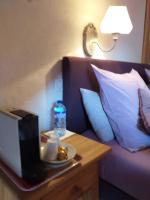 a table with a television and a bottle of water on a bed at Le Bacchu Ber in Briançon