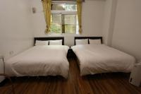 two beds in a room with a window at Cuiti B&amp;B in Fenqihu