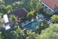Una vista aérea de una piscina con palmeras. en Amatara Agung Raka, en Ubud