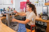 Una donna in piedi al bar che prepara da bere di Camping RCN Belledonne a Le Bourg-dʼOisans