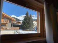 a window with a view of a snow covered mountain at Hotelski in Verbier