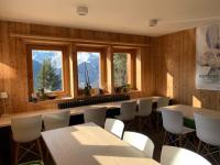 a dining room with tables and chairs and windows at Hotelski in Verbier