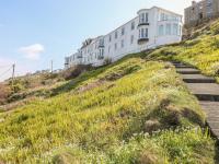 a house on the side of a hill with grass at Sennen Heights in Sennen Cove