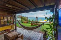 a porch with a hammock and a view of the ocean at Pousada DiMari in Boicucanga