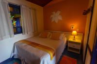 a bedroom with a bed and a window and a lamp at Pousada DiMari in Boicucanga