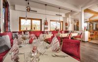 a dining room with tables and red chairs at Der Burgfellnerhof - Adults Only in Schladming